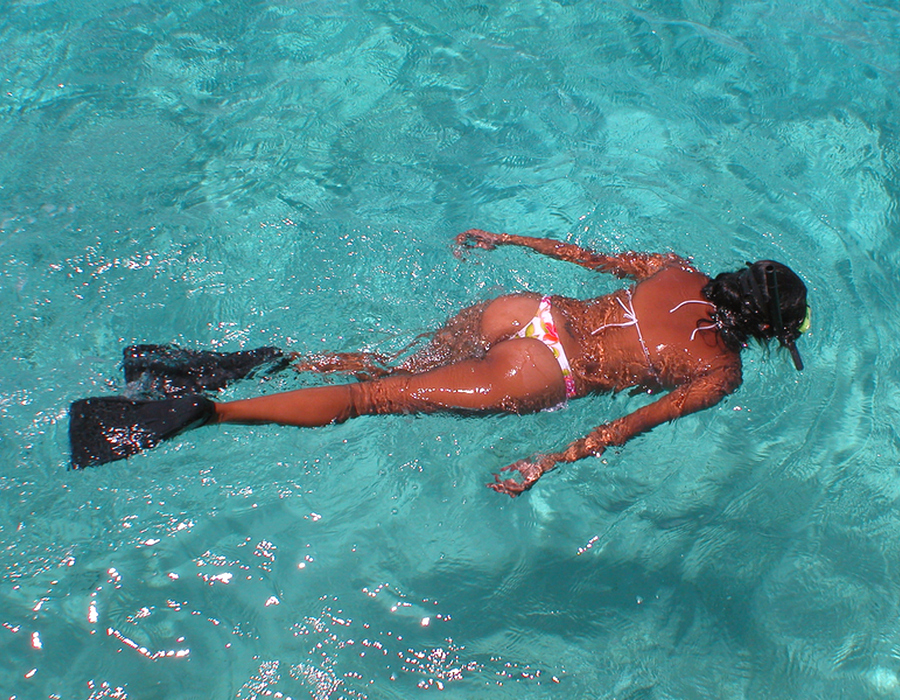 Девушка, плавающая в ластах в бассейне под открытым небом